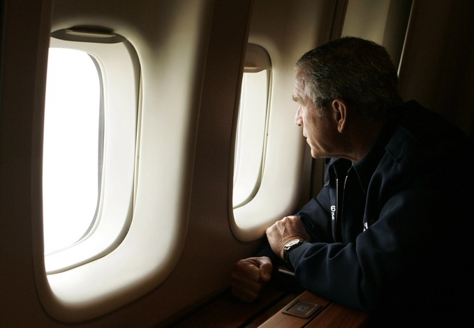 President Bush looks out the window of Air Force One inspecting damage from Hurricane Katrina while flying over New Orleans