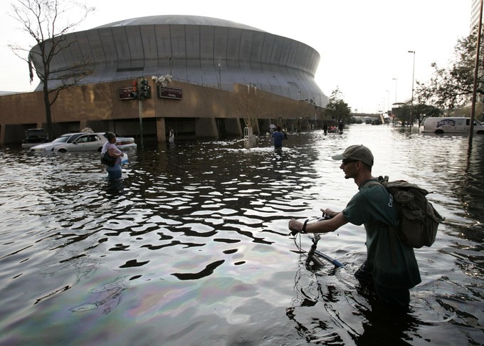 A man pushes his bicycle through flood waters near the Superdome in New Orleans after Hurricane Katrina left much of the city under water. 
